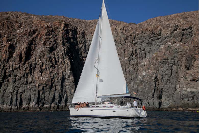 Una barca a vela di fronte alle scogliere di Los Gigantes